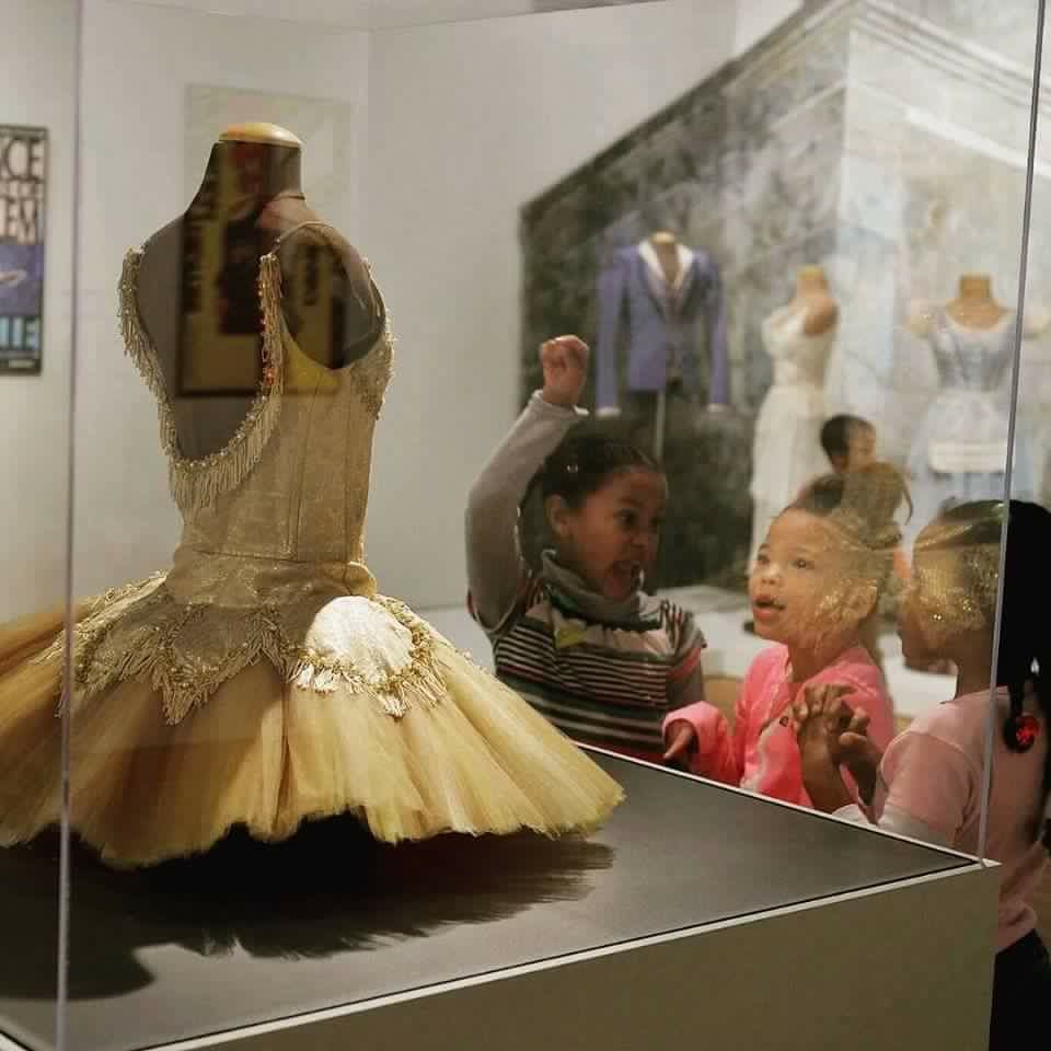 Three young ladies viewing a tutu from Le Corsaire, Dance Theatre of Harlem: 40 Years of Firsts